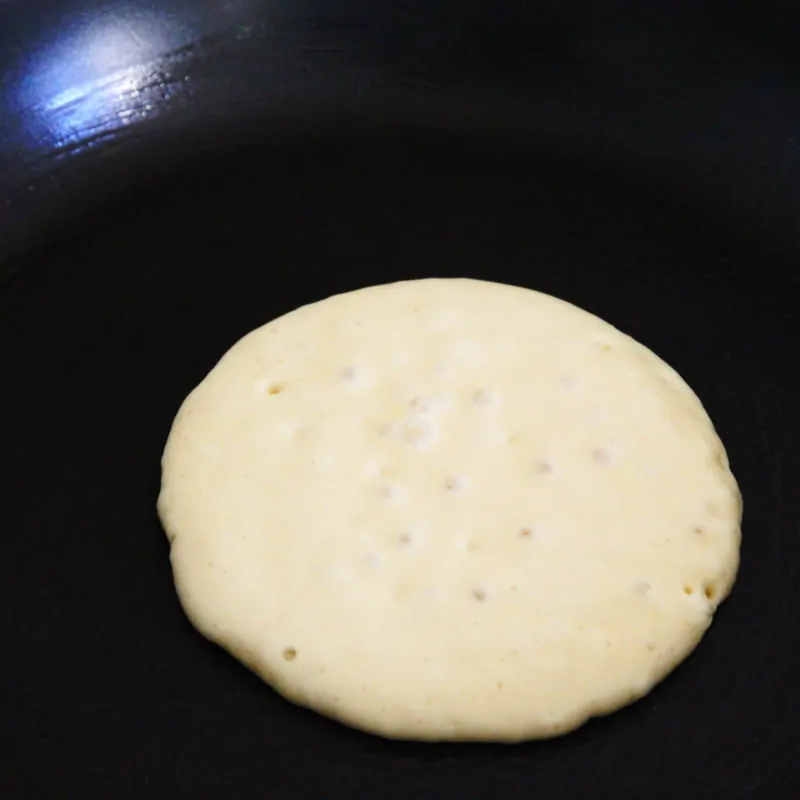 Dorayaki in der Pfanne mit kleinen Blasen an der Oberfläche